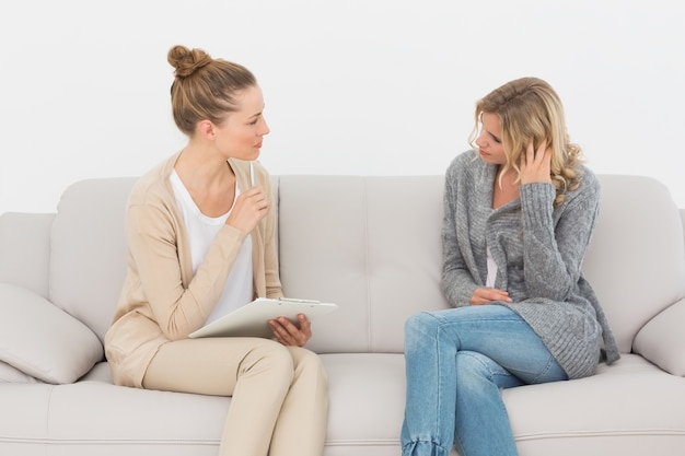 Foto mujer enojada hablando con su terapeuta en el sofá