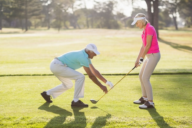 Mujer de enseñanza masculina madura para jugar al golf