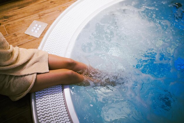 Foto mujer entrando en el jacuzzi en un spa