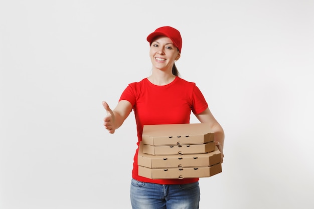 Mujer de entrega en gorra roja, camiseta dando cajas de pizza de pedido de comida aisladas sobre fondo blanco. Mensajero mujer de pie con la mano extendida para saludar, sosteniendo pizza italiana en caja plana de cartón.