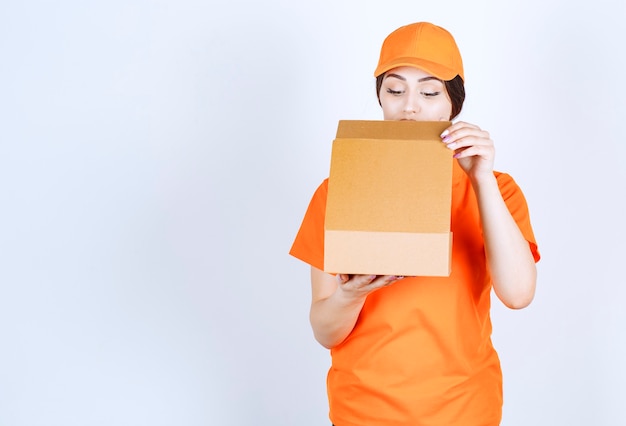 Foto mujer de entrega mirando dentro del paquete