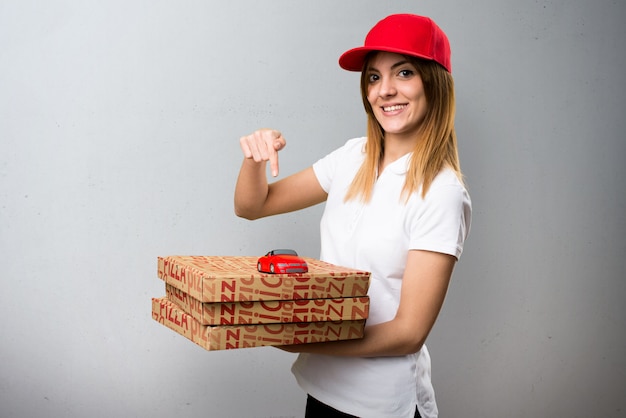 Mujer de entrega de pizza con coche pequeño sobre fondo con textura