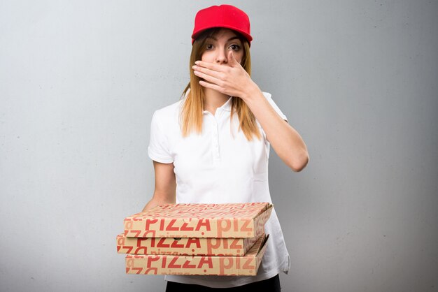 Mujer de entrega de pizza cubriendo su boca sobre fondo con textura