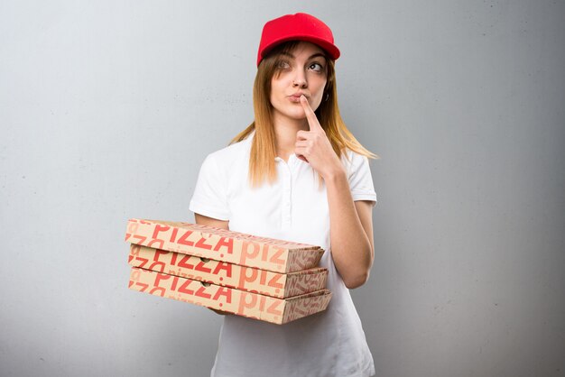 Mujer de entrega de pizza pensando en fondo con textura