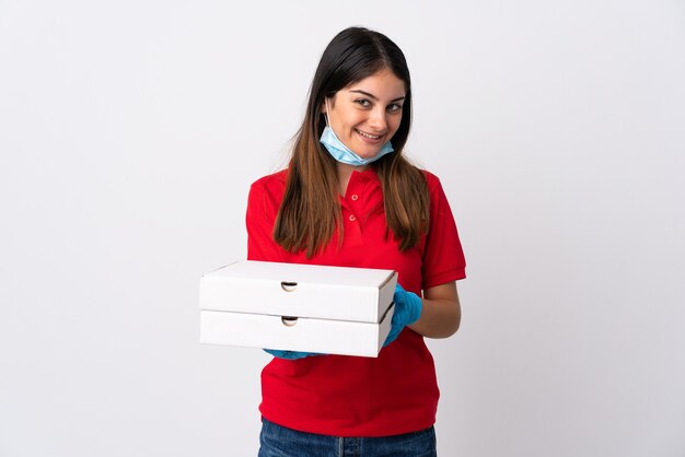 Foto mujer de entrega de pizza sosteniendo una pizza aislada en la pared blanca con expresión feliz