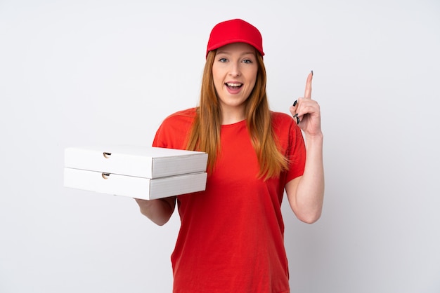 Mujer de entrega de pizza sosteniendo una pizza sobre pared rosa aislado apuntando hacia arriba una gran idea