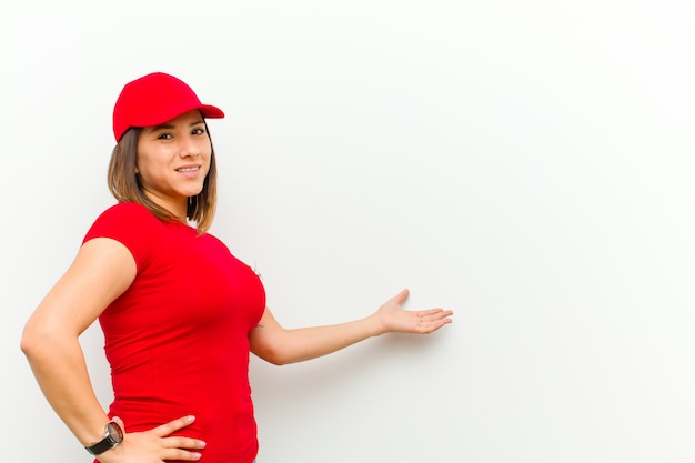 Mujer de entrega que se siente feliz y alegre, sonriendo y dándole la bienvenida, invitándote a entrar con un gesto amable