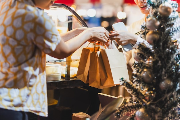 Foto mujer entregando una bolsa de papel con comida a una mujer cliente al aire libre