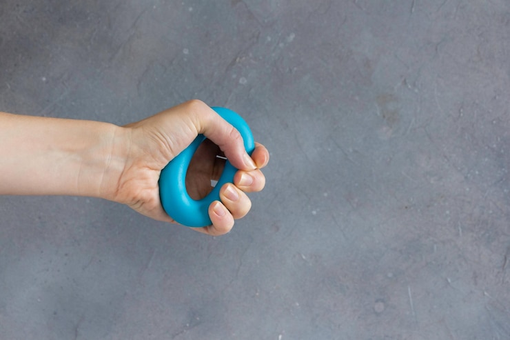 Foto mujer entrena la mano apretando un expansor de goma para fortalecer el brazo el concepto de fuerza y salud