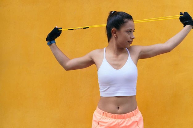 Mujer entrenando con bandas de resistencia de goma