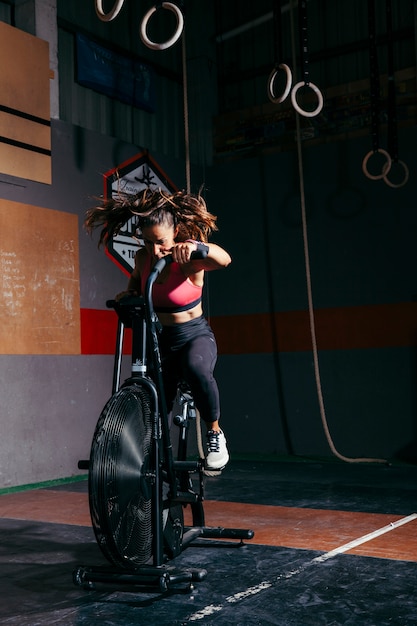 Foto mujer entrenando en bicicleta estática