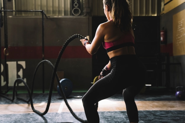 Foto mujer entrenando con cuerda en gimnasio