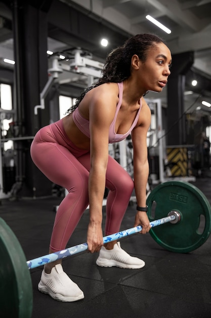 Foto mujer entrenando para levantamiento de pesas en el gimnasio