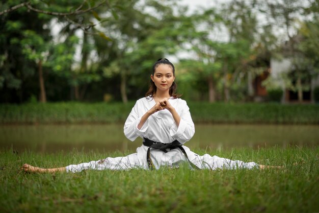 Foto mujer entrenando en taekwondo al aire libre en la naturaleza