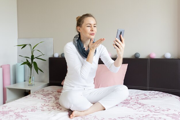 Mujer enviando un beso durante la videollamada telefónica.