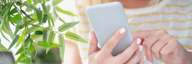 Mujer enviando mensajes de texto en el teléfono móvil o jugando juegos en línea para matar el tiempo