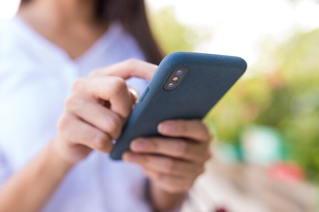 Mujer enviando sms por celular en la ciudad