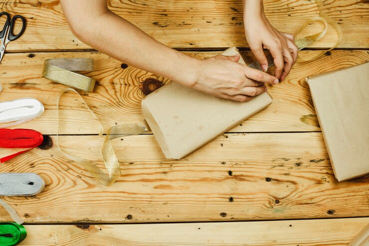 Foto una mujer envolver cajas de regalo de navidad caseras. haz regalos de navidad. regalos de navidad diy para amigos y familiares.