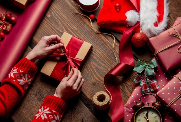 Mujer envolver regalo en mesa de madera