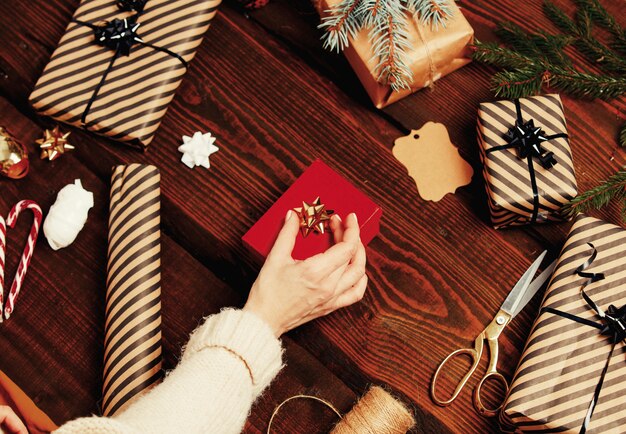 Mujer envolviendo un regalo de Navidad en una mesa