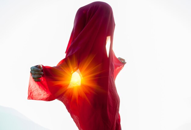 Mujer envuelta en un pañuelo rojo en el viento