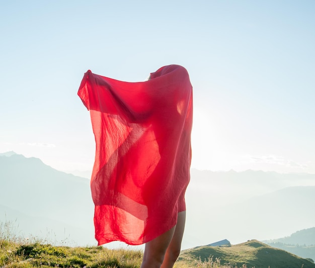 Foto mujer envuelta en un pañuelo rojo en el viento