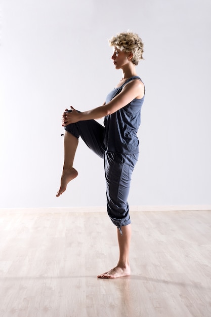 Mujer equilibrada sosteniendo la rodilla