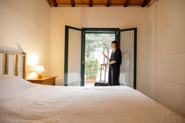 Mujer con equipaje en la habitación del hotel de estilo antiguo