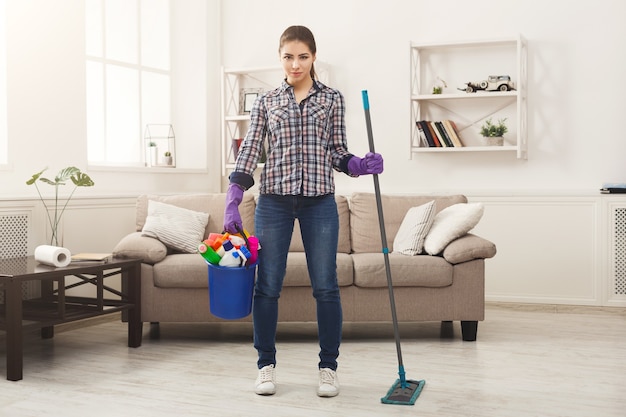 Mujer con equipo de limpieza listo para limpiar la habitación