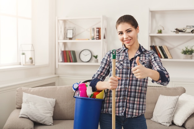 Mujer con equipo de limpieza listo para limpiar la habitación