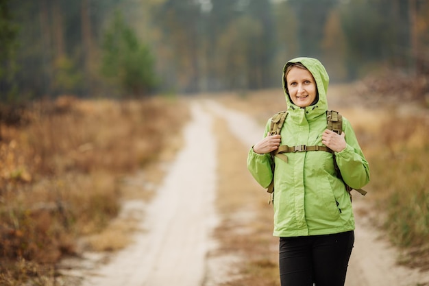 Mujer con equipo de senderismo caminando en el bosque