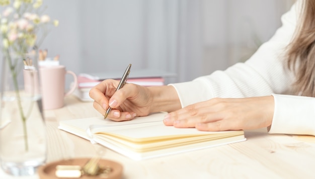 Mujer escribe en cuaderno