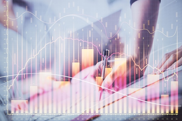 Una mujer escribe información sobre el mercado de valores en el bloc de notas Hologramas de gráficos Forex delante Concepto de investigación Doble exposición