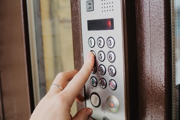 Mujer escribiendo un código pin para desbloquear una puerta de código digital electrónico inteligente foto de alta calidad