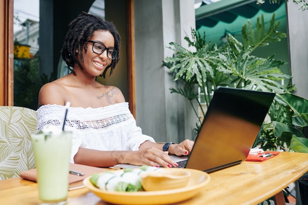 Mujer escribiendo en la computadora portátil