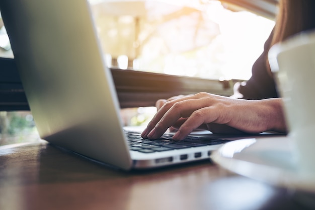 mujer escribiendo en la computadora portátil