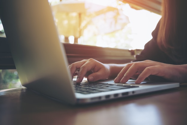 mujer escribiendo en la computadora portátil