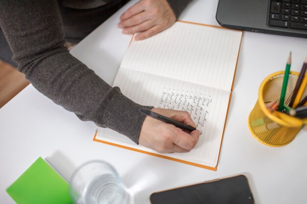 Mujer escribiendo en un cuaderno una lista de reglas para la salud mental