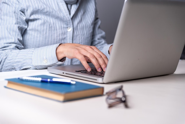 Mujer escribiendo en un libro de computadora anteojos copia espacio lectura educación concepto enfoque selectivo