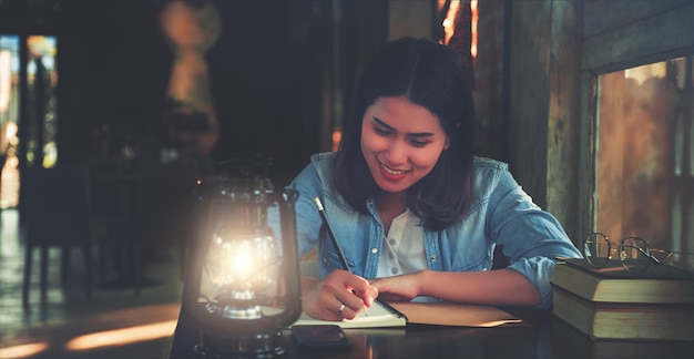 Mujer escribiendo en un libro en la mesa