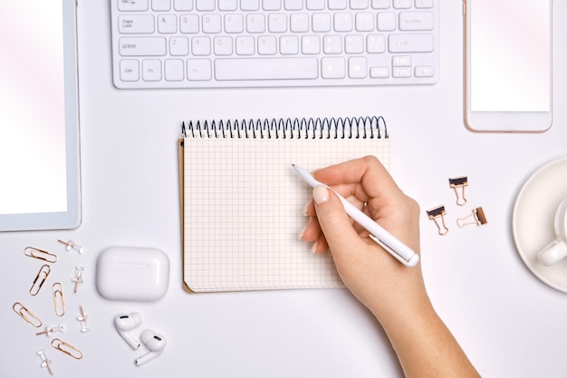 Mujer escribiendo en una lista vacía en el bloc de notas para hacer la lista