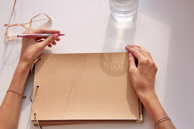 Foto la mujer está escribiendo con la mano izquierda en un papel de artesanía álbum álbum maqueta día internacional de zurdos