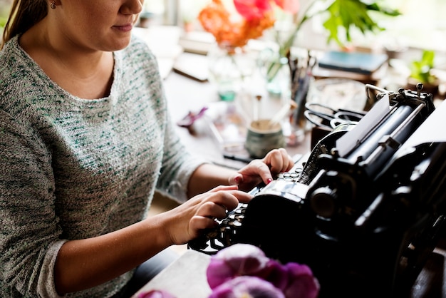 Mujer escribiendo en una máquina de escribir vintage