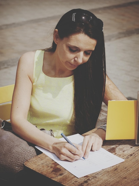 Foto mujer escribiendo en el papel en la mesa