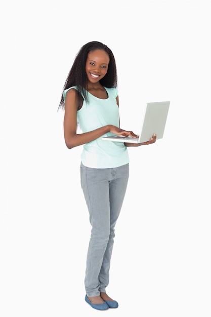 Mujer escribiendo en su computadora portátil sobre fondo blanco