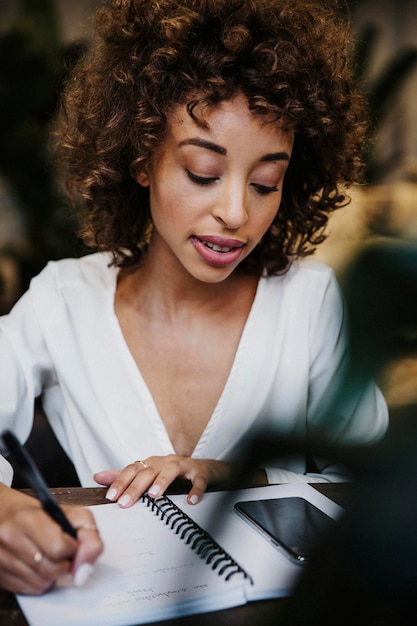 Mujer escribiendo en su cuaderno