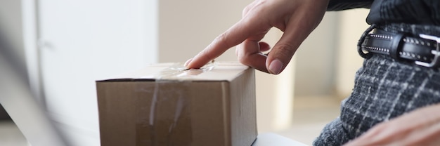 Mujer escribiendo en el teclado cerca de la caja de cartón closeup concepto de compras en línea