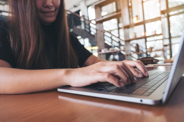 Foto mujer escribiendo en el teclado de la computadora portátil