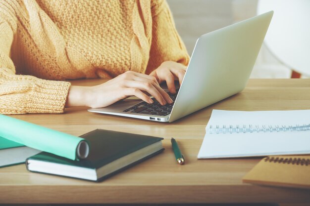 Mujer escribiendo en el teclado del portátil