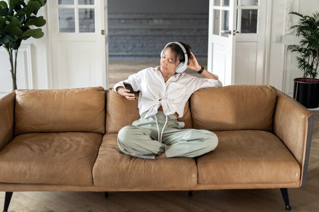 Foto una mujer escucha música tranquila con auriculares usando una nueva aplicación de equilibrio y armonía